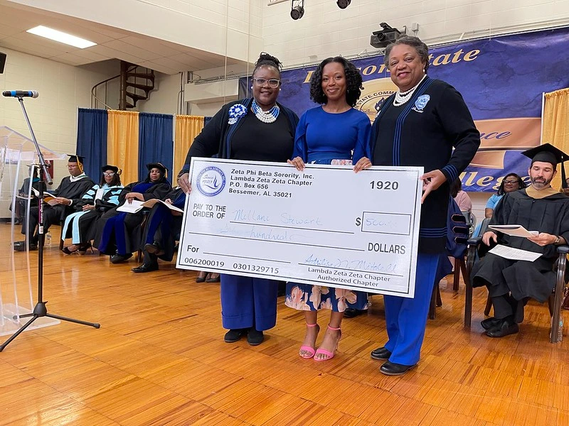 Two women giving check to lawson state student 