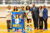 A Lawson State volleyball senior wearing jersey number 8 is recognized on the gym court with flowers and gifts, standing with family and staff next to a large poster reading "Jala Blackwell."