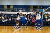 Lawson State volleyball players celebrate a point on the court with raised arms near the net, while spectators watch from the bleachers behind them.