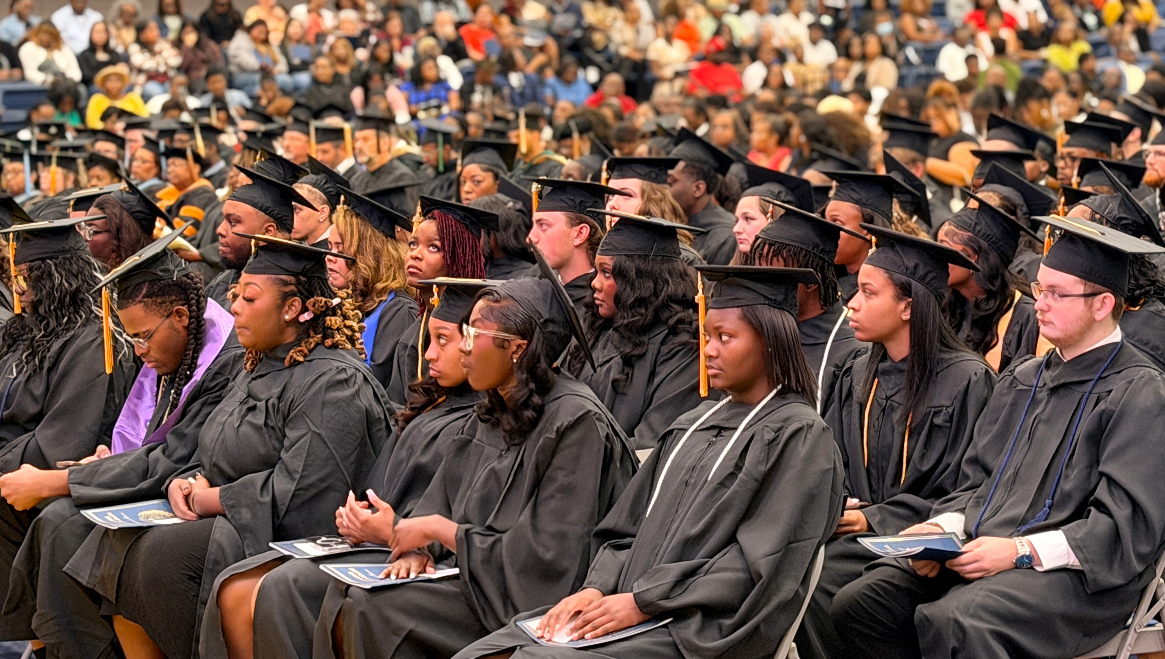 Lawson State students in black caps and gowns face the stage at graduation in May 2026
