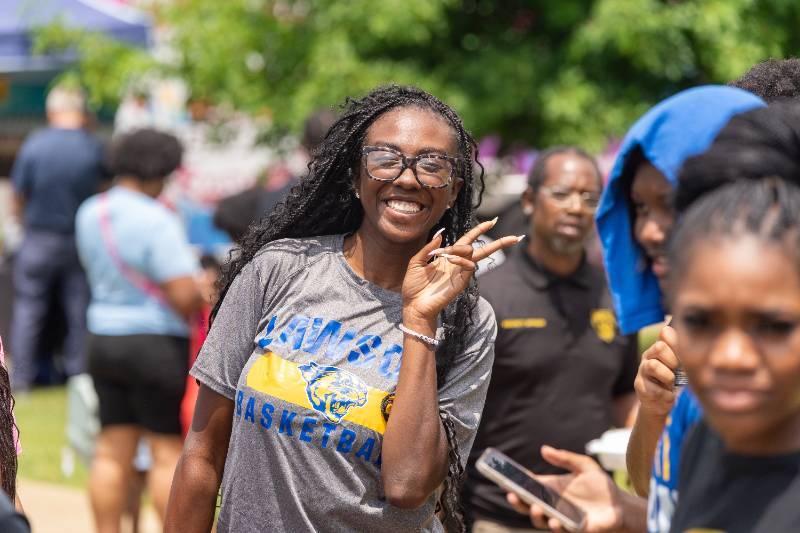 woman with braids flashes peace sign and a smile during cougar fest 2025 at lawson state