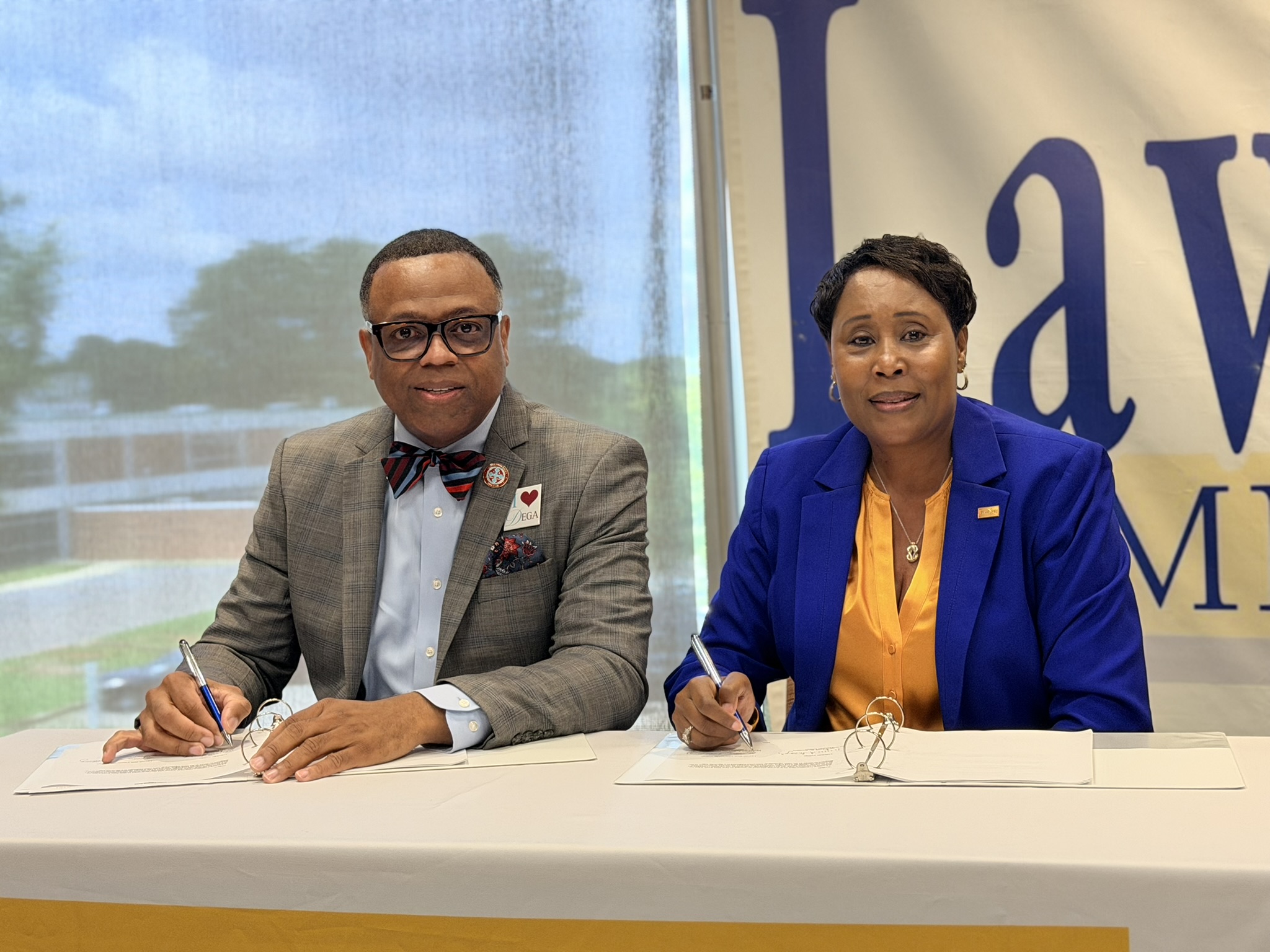 College presidents Dr Willie Todd Jr and Dr Cynthia T Anthony sit at table to sign transfer agreement